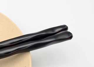 Toki Meki Workshop black lacquered wooden chopsticks with a wavy design, 23cm length.
