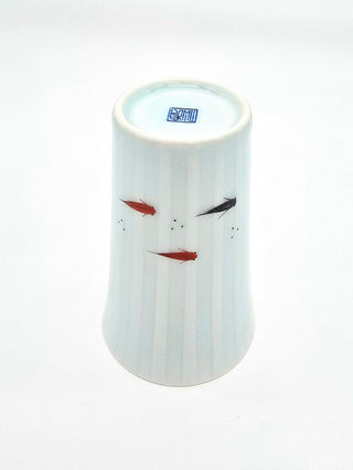 Toki Meki Workshop light blue porcelain cup with painted red and black medaka fish and subtle vertical stripes.