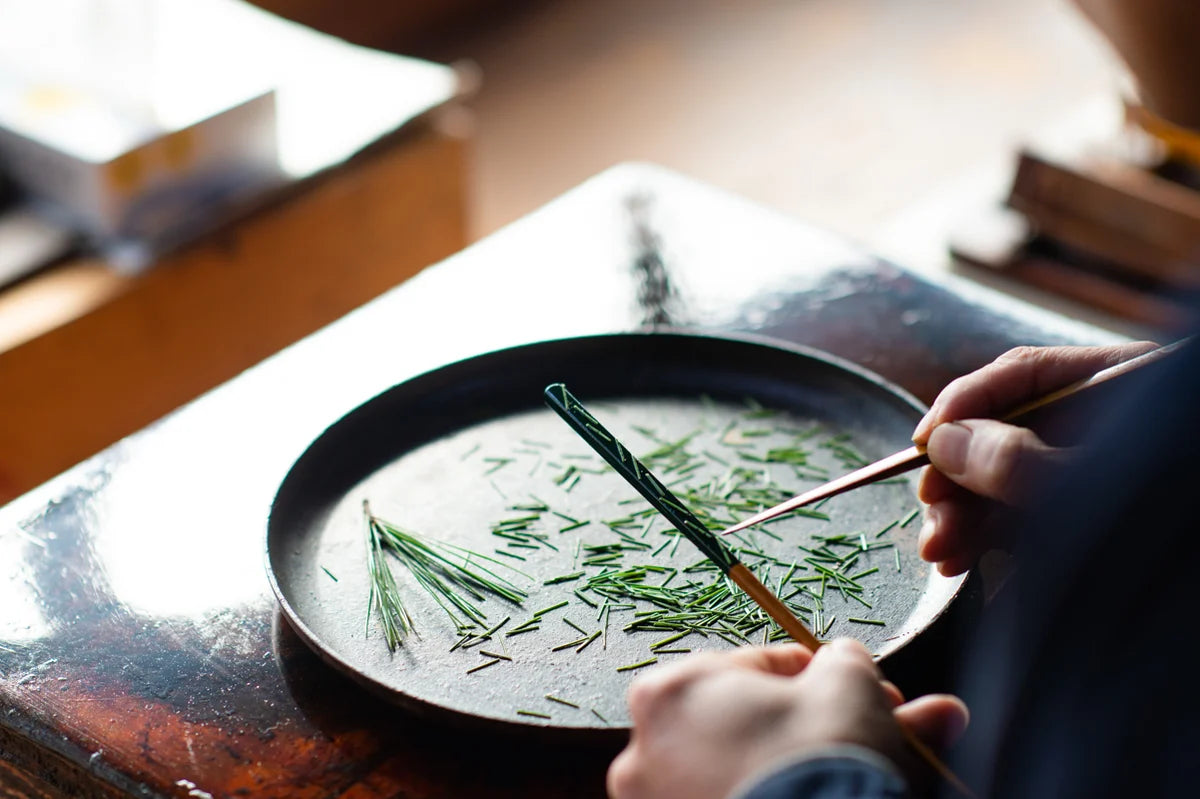 Matsukan artisan applying a traditional chopstick finish by hand